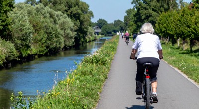 Firefly Fietsende Oudere Mensen Langs Een Waterloop Met Aan De Andere Kant Van De Weg Struikgewas 85